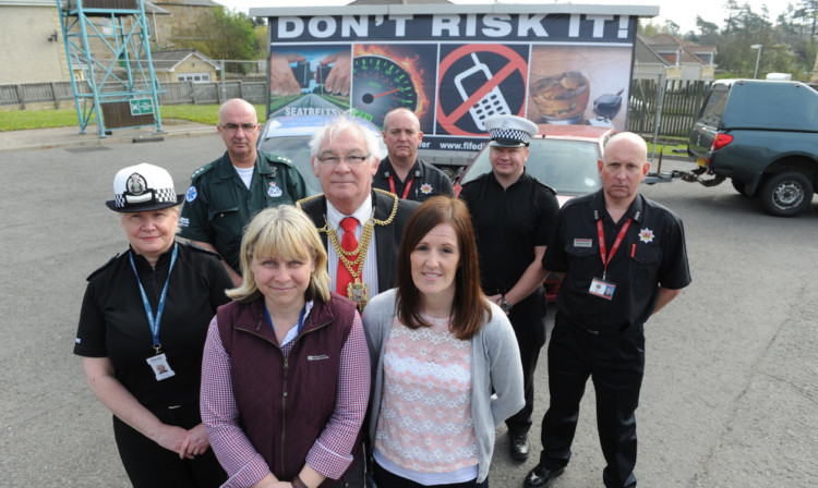 At Cupar Fire Station for the launch of Cut It Out are, back, from left, paramedic John Anderson (area service manager), Scottish Fire and Rescues Iain Vincent (local senior officer), PC Alex Ellis (road policing officer) and Scottish Fire and Rescues Stephen Thomson (station manager). Front: Inspector Brenda Sinclair (road policing unit), Gillian Kelly (road safety officer), Fife Provost Jim Leishman and Nicola Philp (development officer).