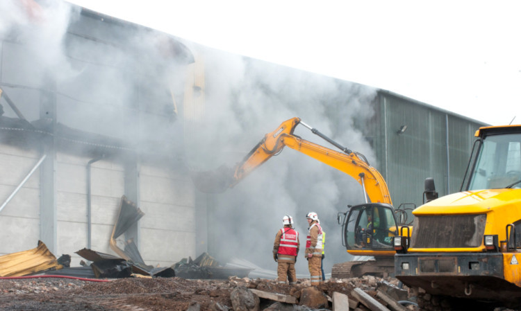 A digger is used to tear open the recently constructed building.