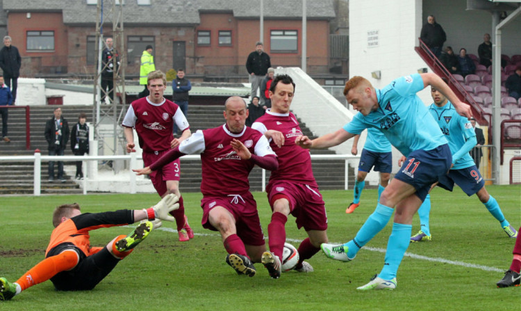 Arbroath work hard to block a shot from Dunfermlines Ryan Thomson.