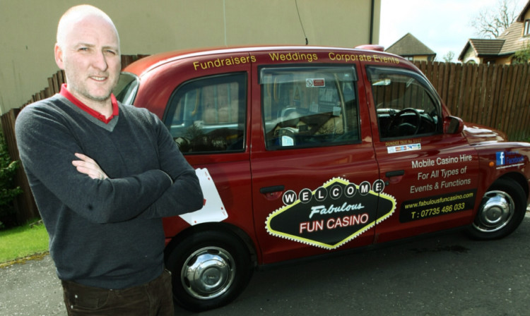 Taxi driver Lance Fraser with his ad-covered taxi, which shows the limit for wrap-around advertising.