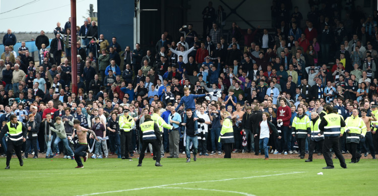 Dundee have won the Championship and promotion to the Premiership next season. A 2-1 win over Dumbarton was enough to seal the title and spark wild celebrations from the capacity crowd at Dens Park. Photo shows fans in the Derry erupting on to the pitch as victory is confirmed.