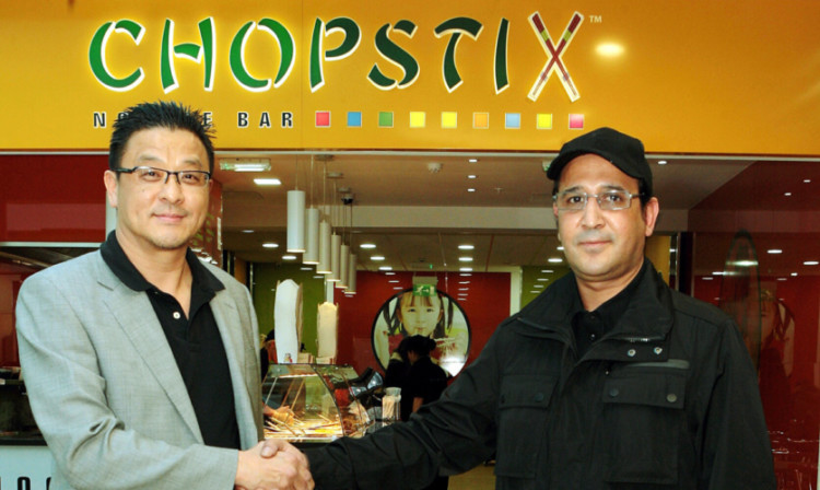 Steve Chow, left, of Chopstix on St Andrews Street, shakes hands with Charki Tsate Hamid of Chopstix Noodle Bar in the Overgate.