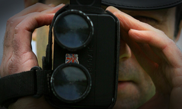 A police officer checking drivers' speeds.