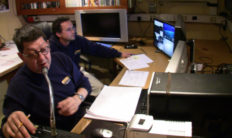 Neil Cunningham Dobson (left) monitors images captured by a sub scanning a wreck.