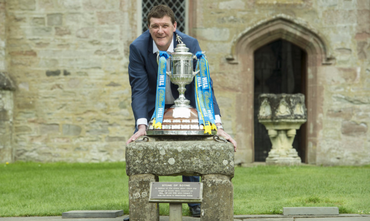 Tommy Wright with the William Hill Scottish Cup resting upon the Stone of Scone.