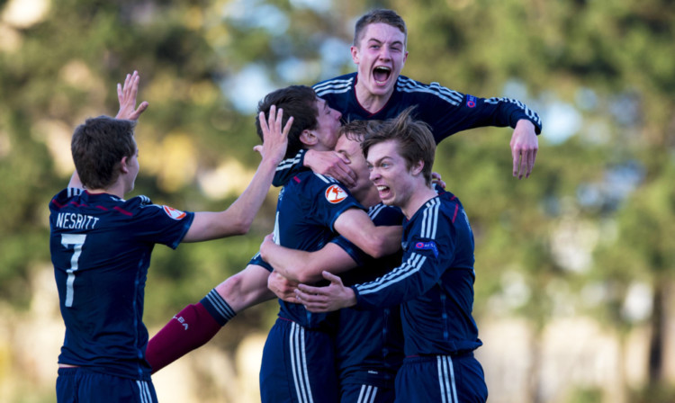 The Scotland players mob scorer Jake Sheppard (centre) after his goal against Switzerland.