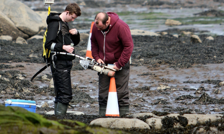 Workers from AMEC check for radioactive particles at Dalgety Bay.