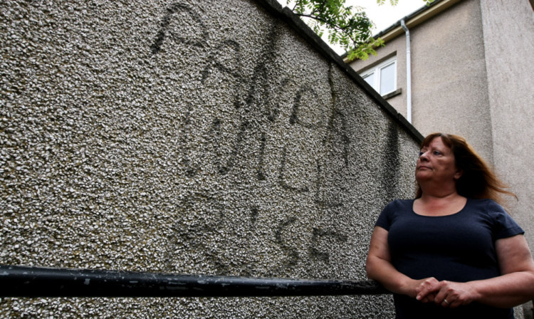 Sue Thomson beside the graffiti outside her home in Kirriemuir.