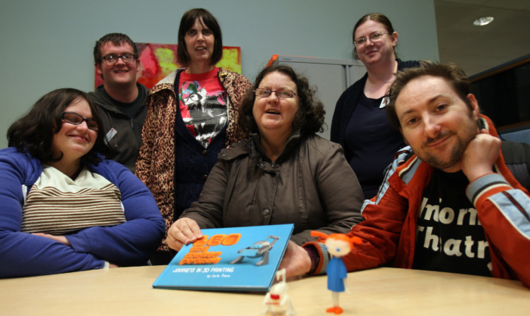 From left: Susan Gerrard, co-facilitator James Keegans, Donna Sorie, Margaret McKay, group facilitator Nicky Welch and Grahame Lapham with the book and characters created using the 3D printer at Central Library.