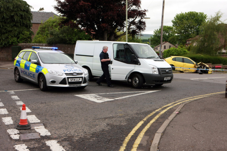 Bob Douglas, Evening Telegraph. Car smashed into a garden wall on Harestane Road near the junction with Strathmartine Road and Laird Street. Pic shows Scenes of Crime Officer (SOCO) and police car with the damaged yellow car, right.