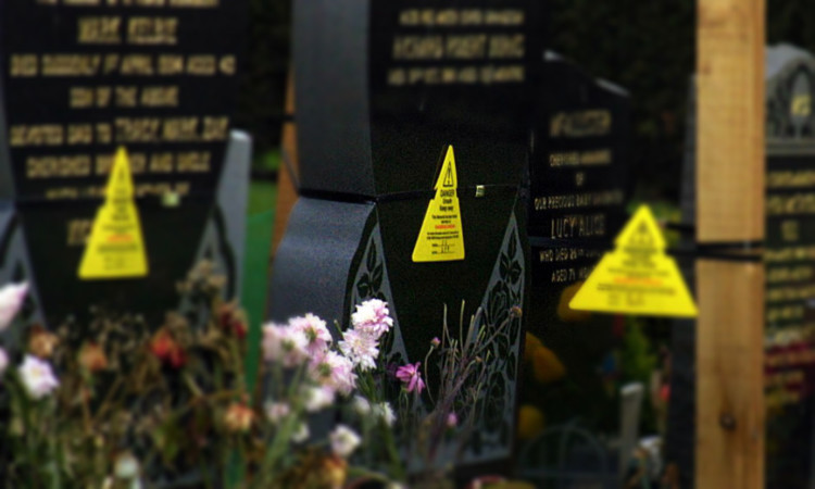 Warning signs placed on gravestones during previous safety checks in Dundee.