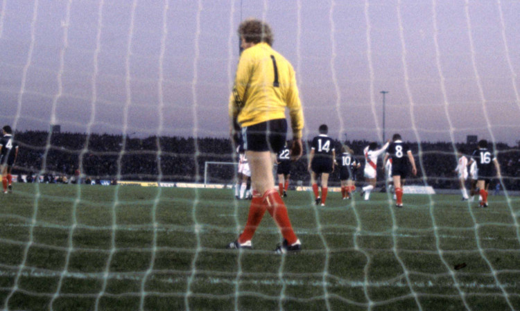 Scotland goalkeeper Alan Rough looks dejected as Peru players celebrate another goal.