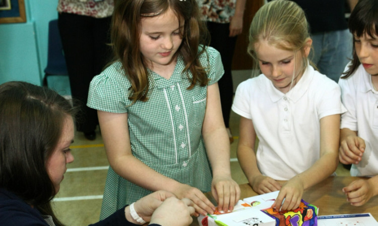 Jennifer McGinley, left, a graduate working with Babcock, helps pupils to build a model of the aircraft carrier.