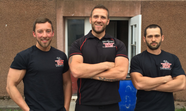 Lee Page, who will organise the strongman event, with Warren Bell, left, and Ivan Grozev, right, members of the Warehouse/Bodyworx Gym.