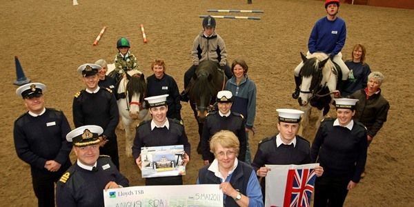 Kim Cessford, Courier, - 05.05.11 - some of the operational crew of HMS Montrose paid a visit to the Angus RDA at Inverarity during a visit to the area to present the charity with a cheque for £500  - they are pictured with volunteers at the centre and some of the riders who make use of the facilities with front l to r - Commander Jonathan Lett and Elinor Phillips accepting the cheque