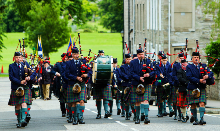 The Perth and District Pipe Band lead the way.