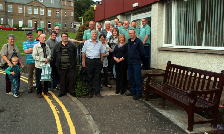 Royal Victoria Hospital staff beside the bench where a plaque has been installed in memory of catering assistant John Hempsall.