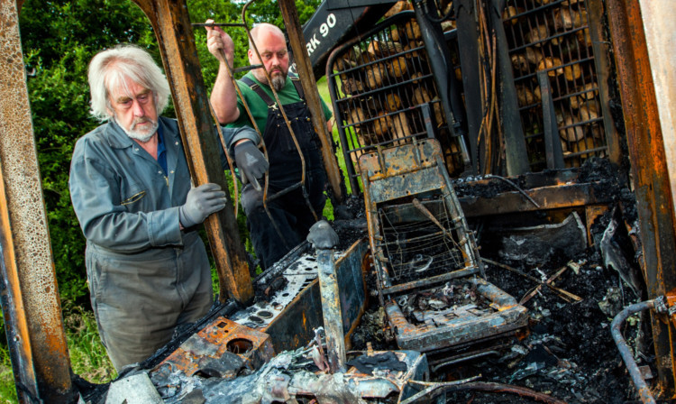 Steven Laing, right, and his father Martin beside the burned-out cab.