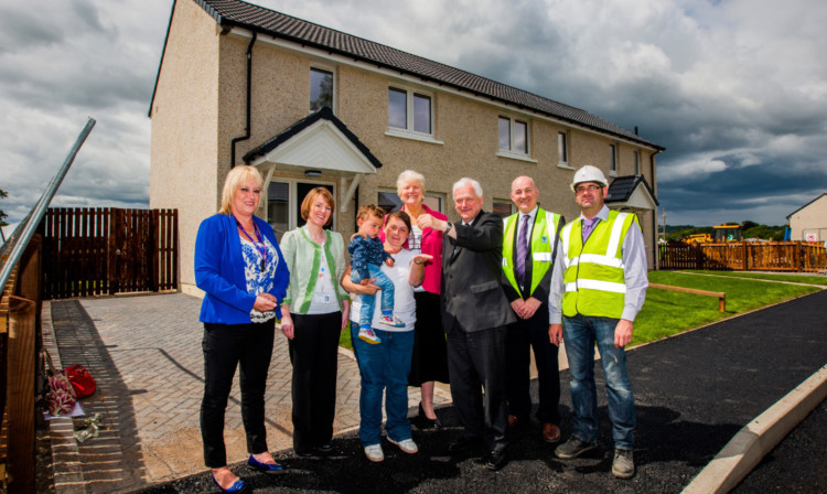 From left: area housing officer Lyndsey Selby, area housing manager Andrea McCallum, Lawana Milne, who will be moving into the house in the background, and her one-year-old son TJ, Provost Liz Grant, Councillor Ian Miller, Perth and Kinross Council project manager Ron Taylor and Muirfield Contracts site manager Willie Childs.