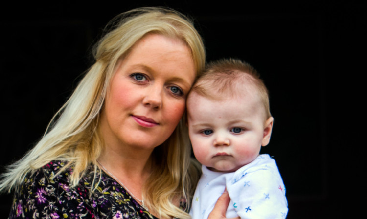 Shirley McArthur and her baby Keir Hughes, whose passport she is waiting for.