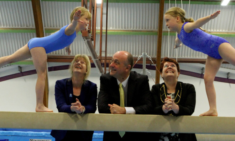 MSP Shona Robison, sportscotland chief Stewart Harris and Depute Provost Christina Roberts watching watching twin sisters Bethany, left, and Caitlin McRae, on the beam at the funding announcement.