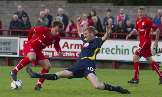 Brechins Gary Fusco puts a tackle in on Dundee midfielder Paul McGowan.