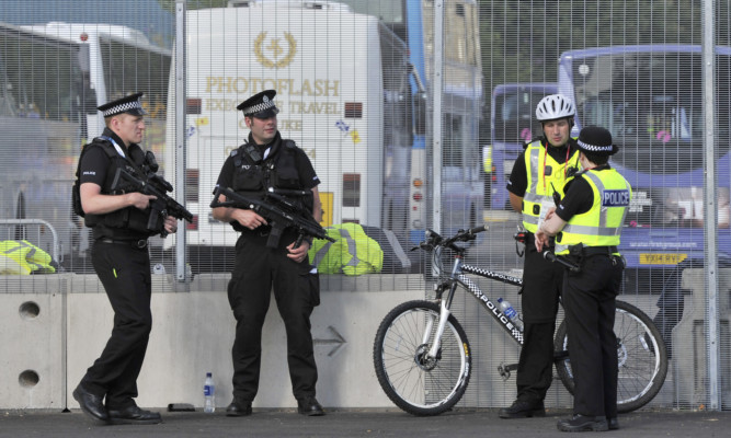 Armed police patrolling a gate at the Commonwealth Games athletes' village.