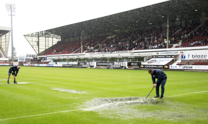 Dunfermline groundsman try their best to make the East End Park pitch playable.