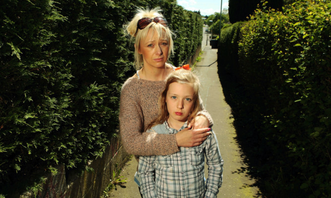 Louise Kerr and her daughter Tia in the lane between Americanmuir Road and Turriff Place where the 10-year-old was jabbed by an abandoned needle.