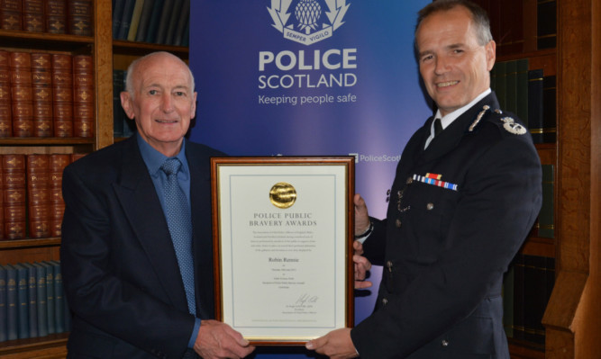 Robin Rennie, 73, accepting the award from Chief Constable Sir Stephen House.