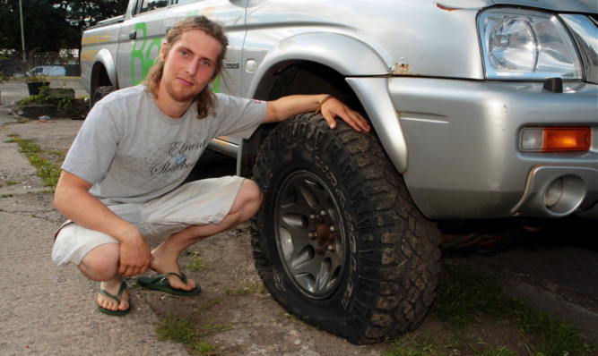 Gardener Benji Walker with his vandalised Mitsubishi 4x4, which had all four tyres slashed.
