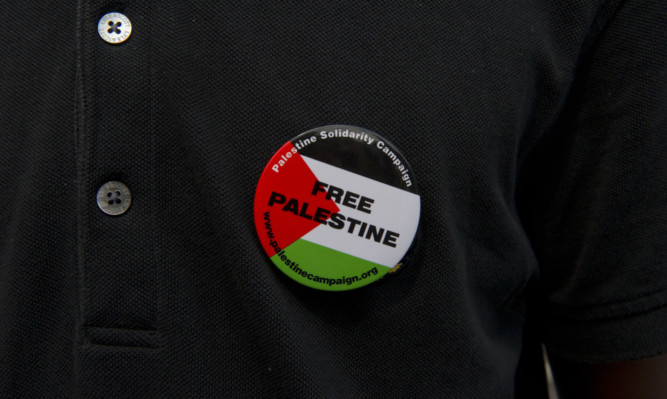 A protester against military action in Gaza wears a 'Free Palestine' badge as he marches through Westminster, Central London. PRESS ASSOCIATION Photo. Picture date: Saturday July 26, 2014. See PA story  . Photo credit should read: Laura Lean/PA Wire