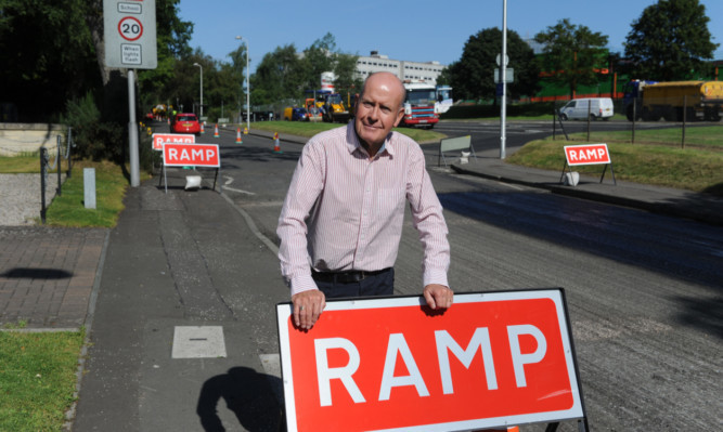 Mr Wilson beside the roadworks.