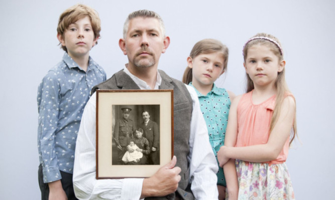 Scott Wishart with his children Alexander, Edith and May, and a photograph of his great-grandparents William and Jessie Wishart, their baby Alexander, and Williams brother, also Alexander, who served with the Cameron Highlanders.