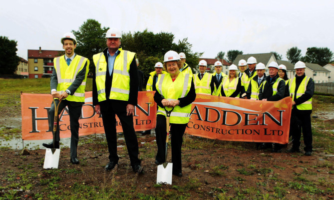 John Alexander, Dundee City Council housing convener, Scott Hadden, chairman of Hadden Construction, Sheena Welsh, Chairman of Angus Housing Association with members of the contractors, archicitecs and hosing to the rear.
