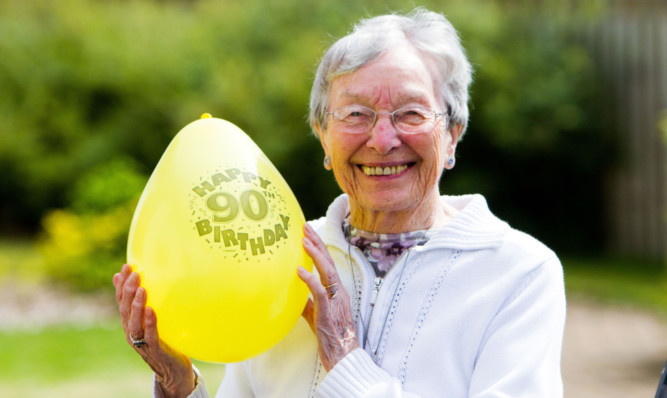 Jessie Buick holds one of the balloons to mark her 90th birthday.