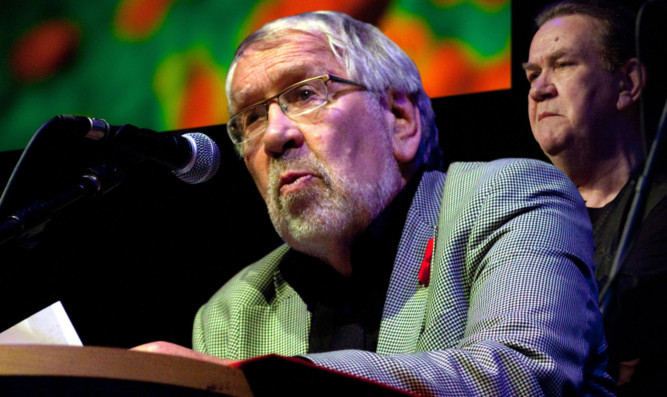 Iain Anderson during a performance, with Dick Gaughan in the background