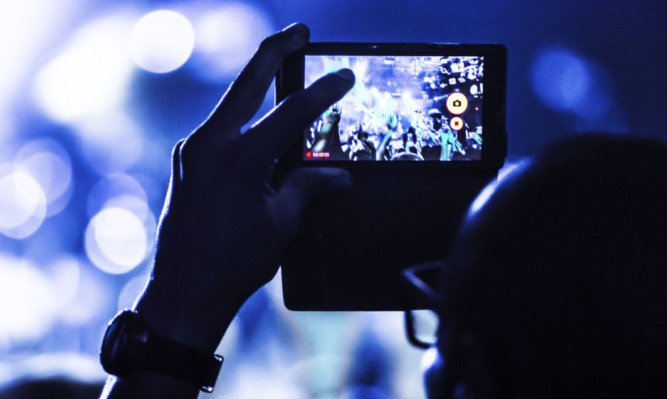 Mobile phones held aloft are now a common sight at most live performances.