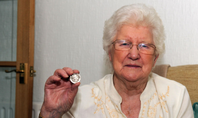 May Freeman and the medal she found in her tin.