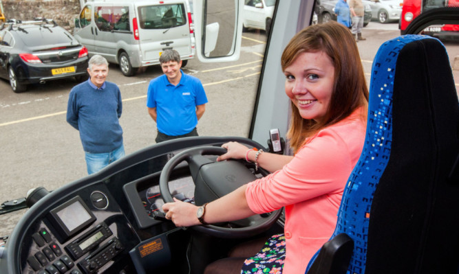 Nicola Docherty in the drivers seat with grandfather Jim, left, and dad William looking on proudly.