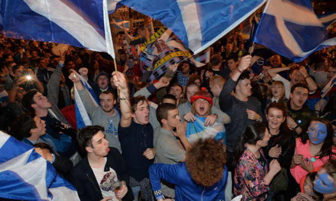 Yes supporters react to the polls closing in George Square in Glasgow.