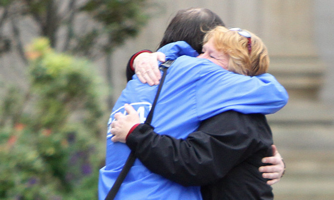 Beaten Yes supporters embrace in Dundee City Square.