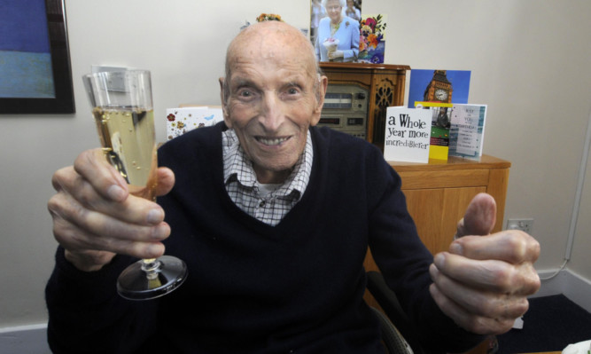 Alex Thomson celebrates with a glass of bubbly.