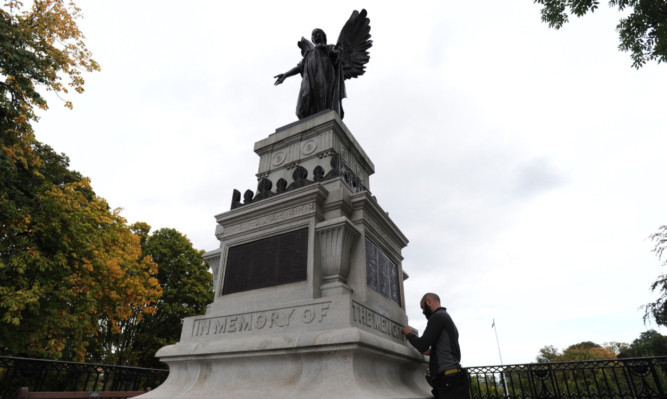 Jonathan Leburn from Graciela Ainsworth sculpture conservation puts the finishing touches to the war memorial.