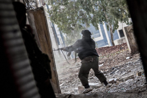 A Free Syrian Army fighter aims his weapon during heavy clashes with government forces in Aleppo.