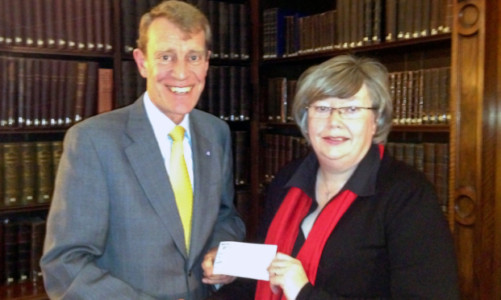 Air Marshal Chris Nickols is presented with the cheque by Gill Howie.