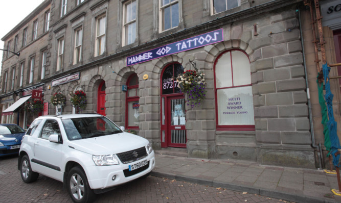 A tattoo studio has been told to remove its sign or face a fine of up to £20,000.