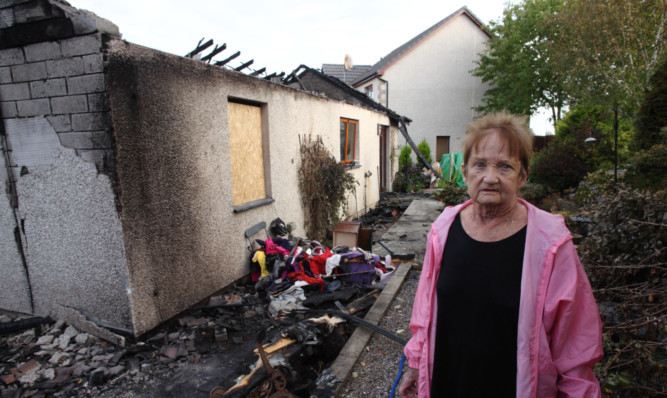 Linda Mair at the burnt remains of her house in Bells Croft, Abernethy. She has said a special thank you to neighbours who have helped her after the blaze.