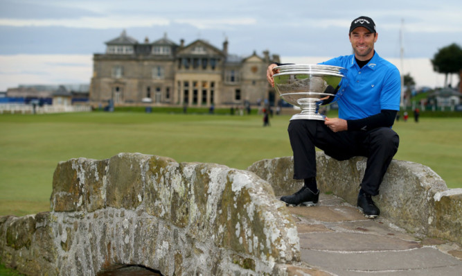 Oliver Wilson sits on the Swilcan Bridge after his one-shot victory in the Alfred Dunhill Links Championship.