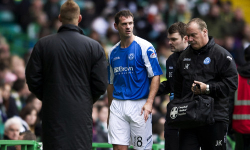 McCracken is helped off the pitch after his injury at Parkhead.